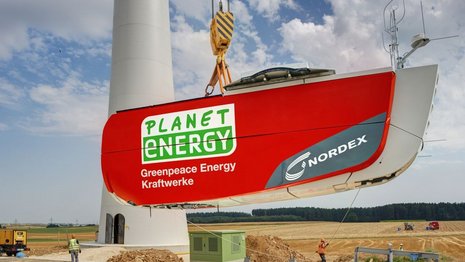 Der Rotor einer Windkraftanlage wird neben der Maste einer Windkraftanlage aus dem Boden gehoben.