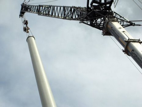 Kran hebt Turm für Windkraftanlage in die Höhe