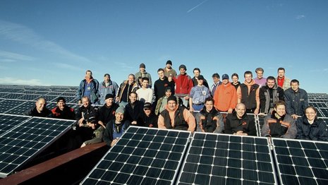 Gruppenbild von Arbeitern vor einer Solaranlage
