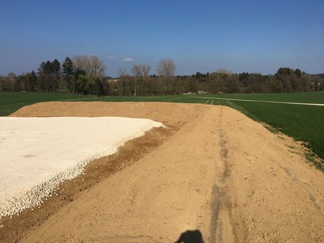 Baustelle mit grünem Park im Hintergrund.