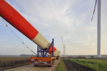 Ein großes Windradblatt wird auf einem Spezialtransporter zur Windkraft Baustelle in Langenbrügge gebracht.