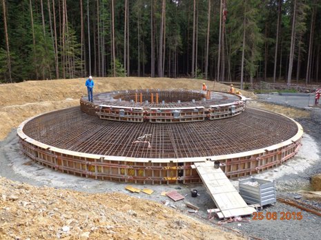 Bau einer Windkraftanlage im Wald: Rundes Betonfundament wird errichtet.