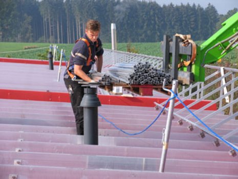 Arbeiter transportiert eine Ladung Schienen zum Montieren