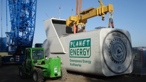 Maschinenhaus mit Aufschrift Planet Energy vor einem Kran