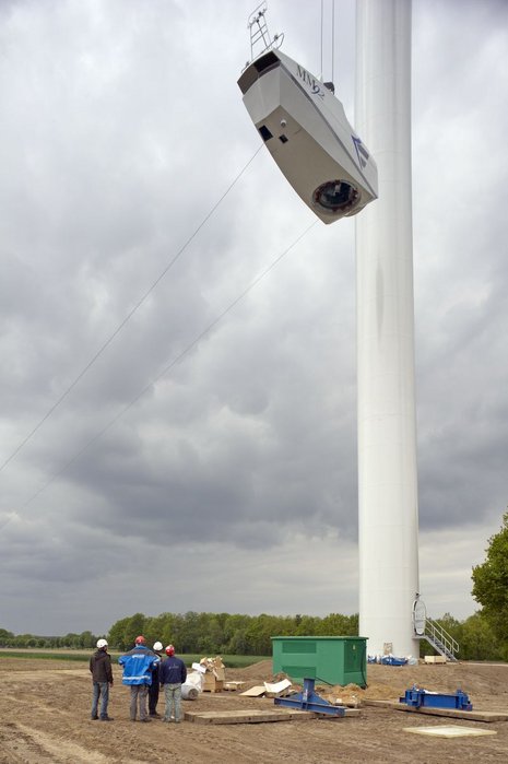Der Rotor einer Windkraftanlage wird von einem Kran in die Luft gehoben.