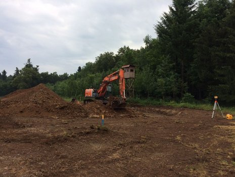 Bagger hebt in einer Baugrube Erde aus