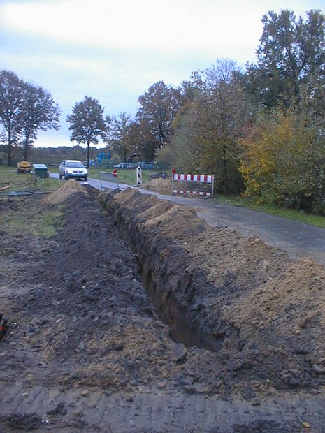 Eine Straße, neben der ein Graben in den Boden gegraben wurde.